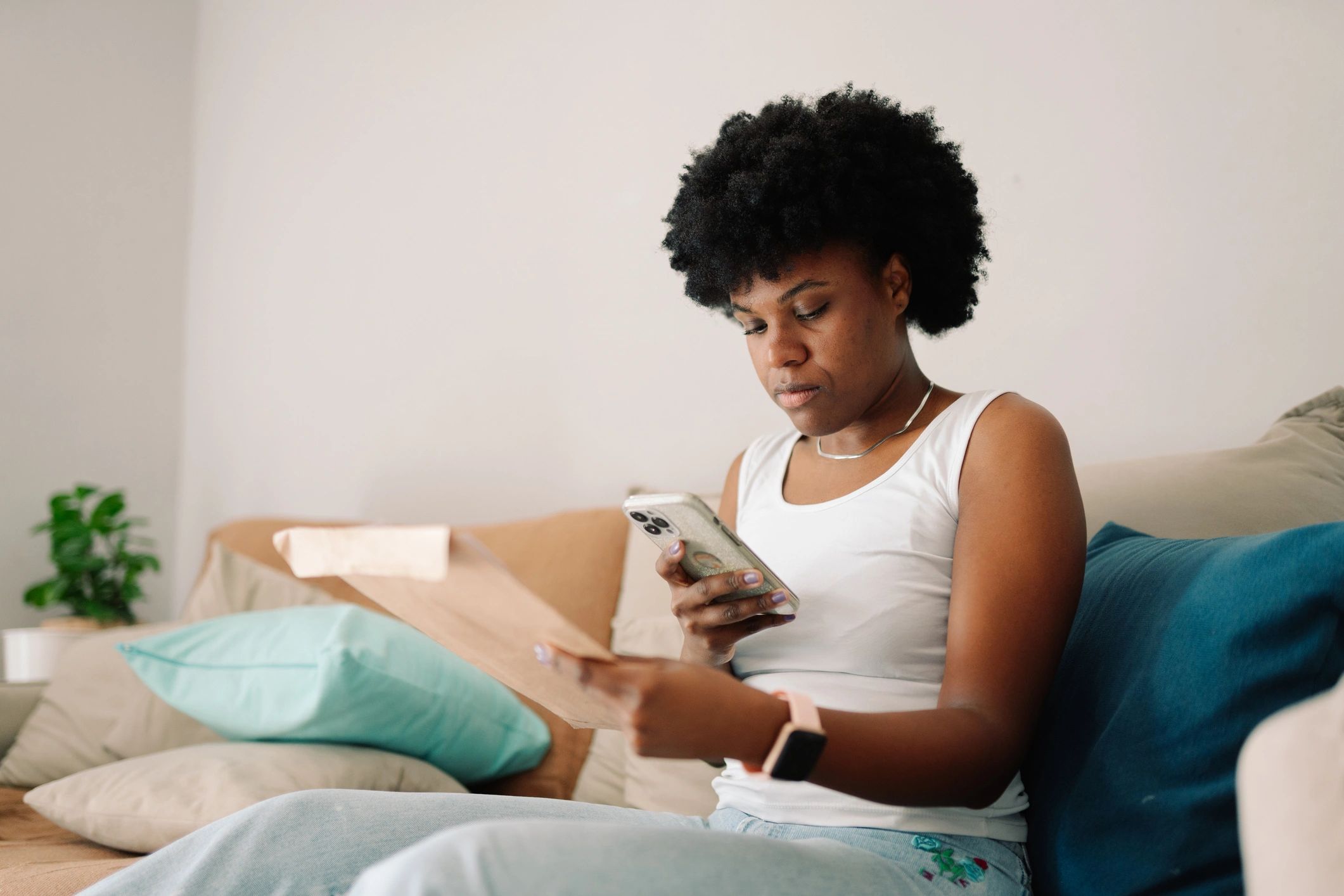 Woman on smartphone relaxing on couch